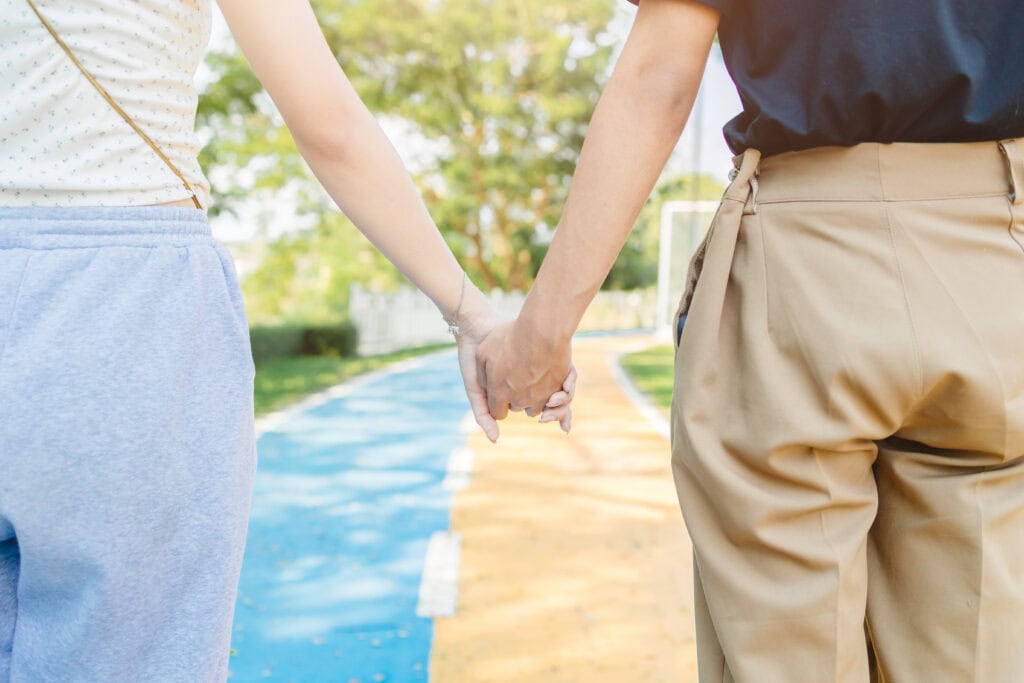 Couple holding hands in nature.
