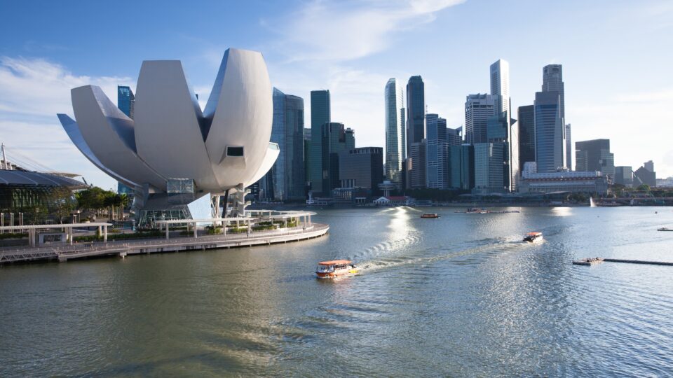 Modern skyline with waterfront and boats.