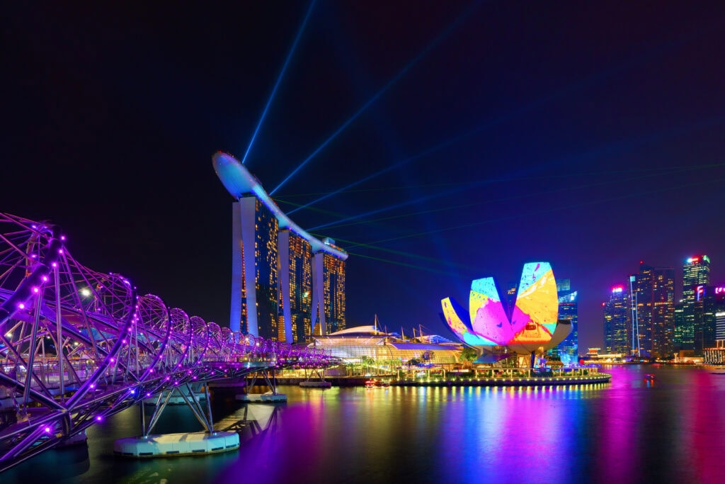 Colorful lights illuminating Singapore skyline.