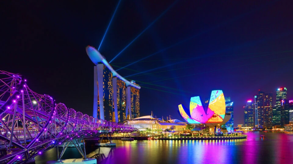 Colorful lights illuminating Singapore skyline.