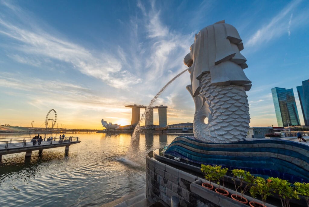 Iconic Merlion statue and Marina Bay Sands skyline in Singapore at sunset.