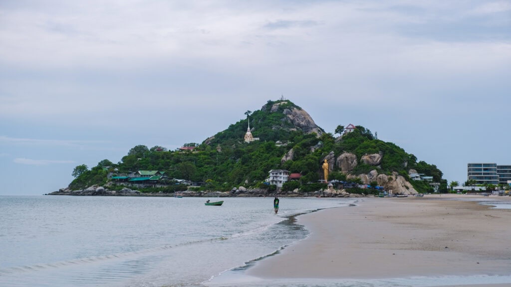 Scenic beach with a hill backdrop.