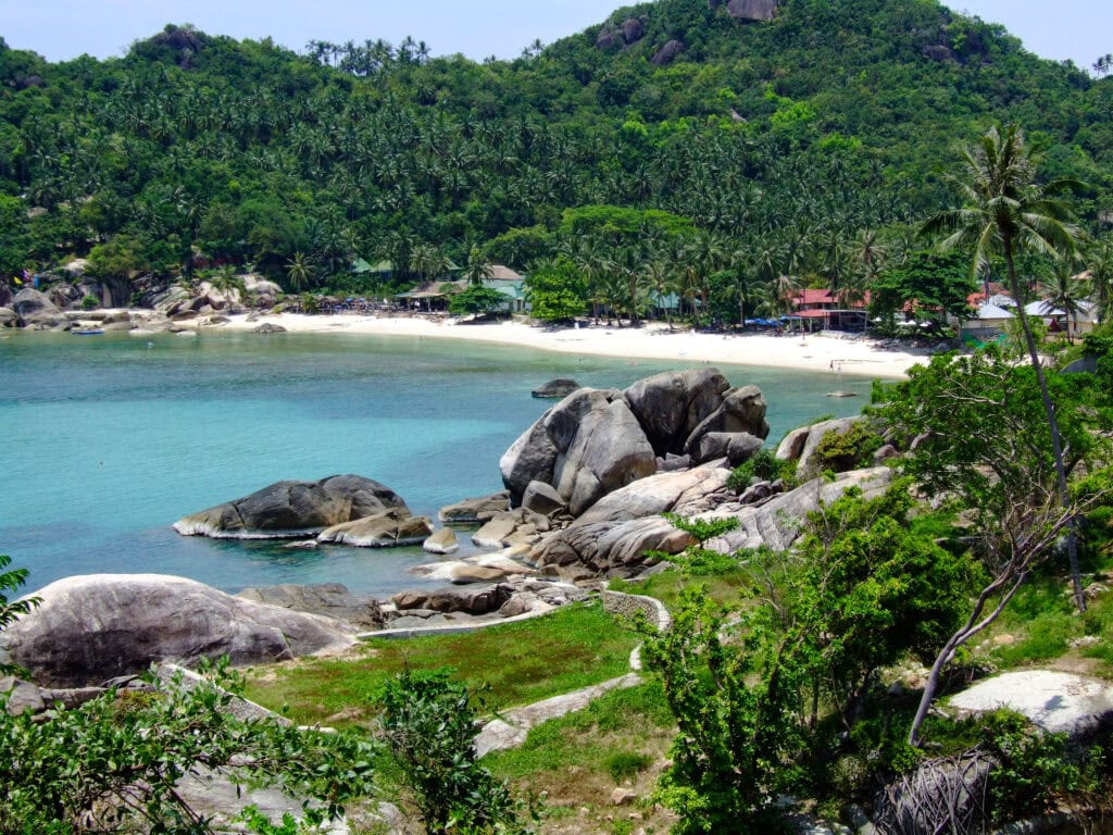 Tropical beach with rocks and greenery.