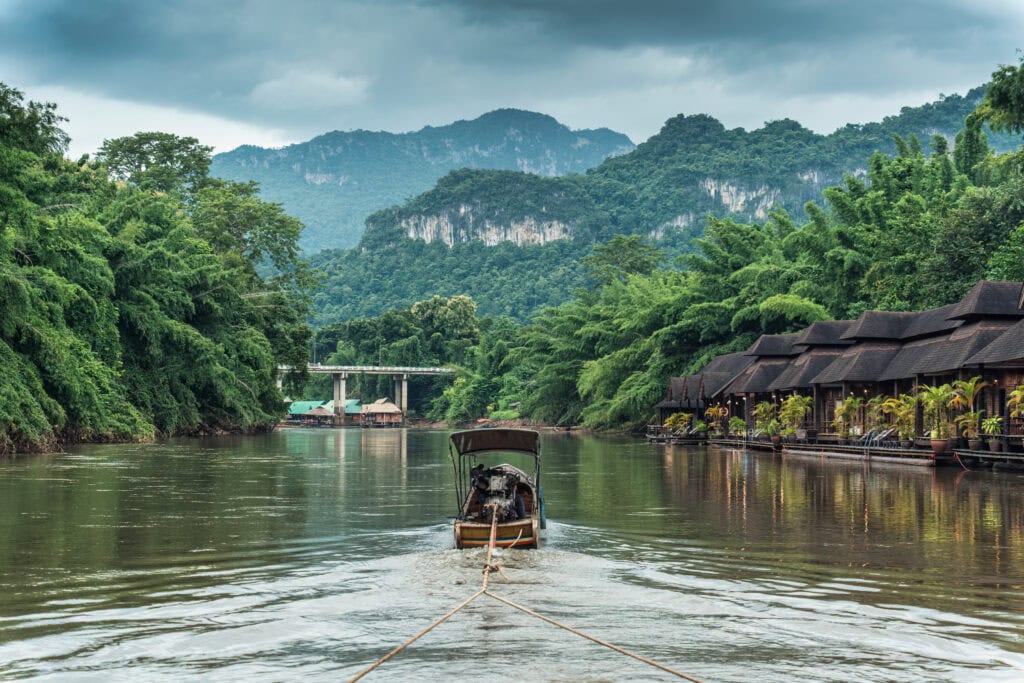 Boat on tranquil river surrounded by greenery.