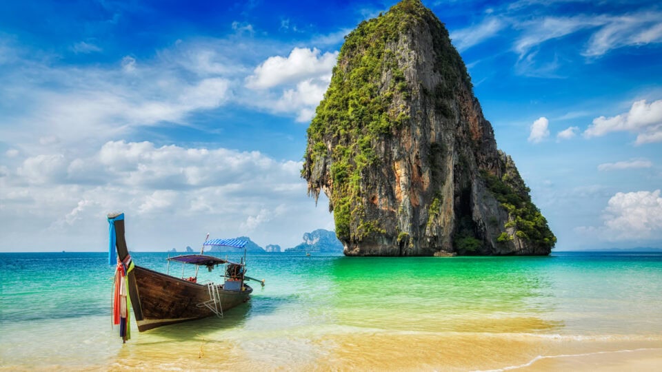 Long-tail boat near tropical island.