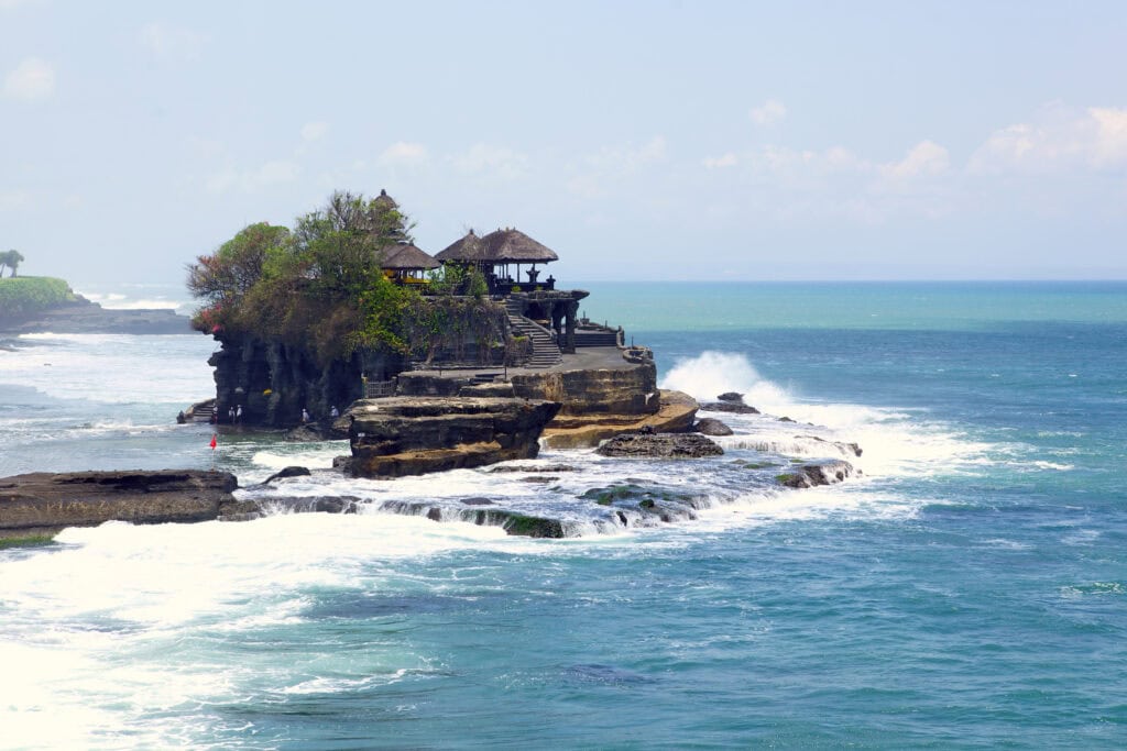 Temple on rocky coast with waves