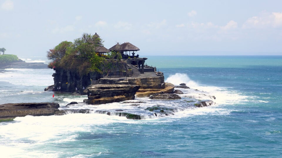 Temple on rocky coast with waves