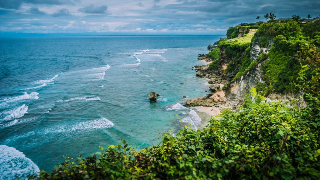 Coastal view with waves and cliffs.