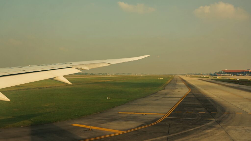 Airplane wing over runway landscape