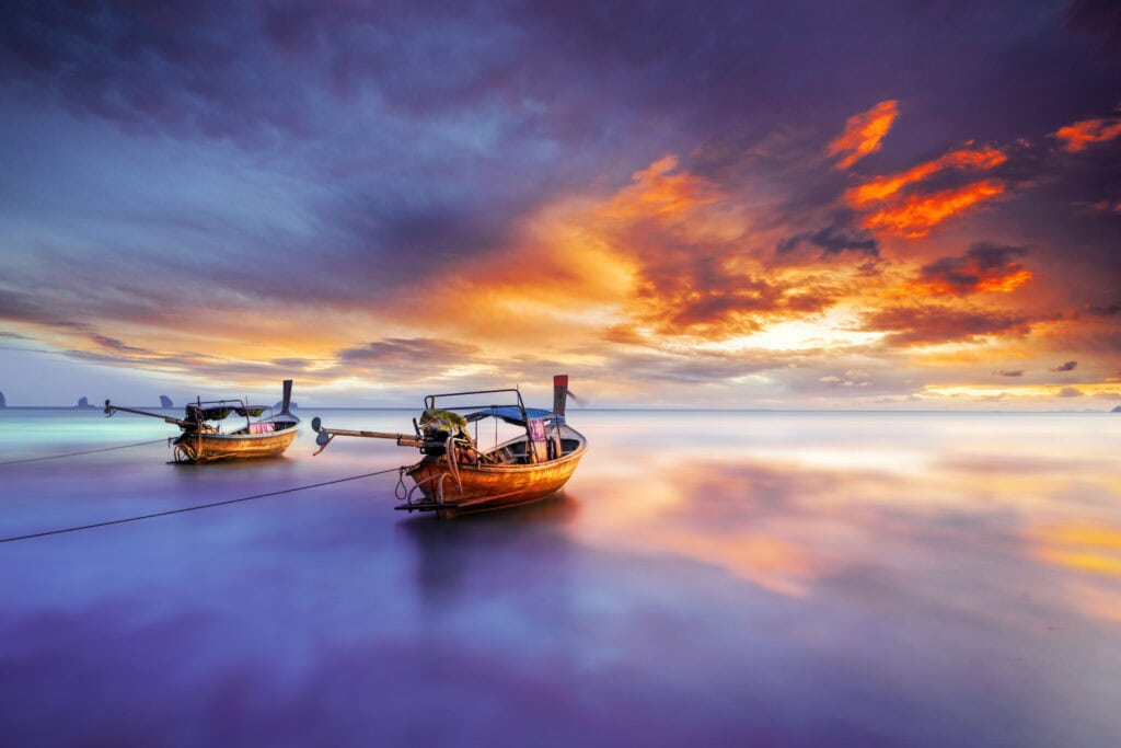 Serene boats under a colorful sunset.