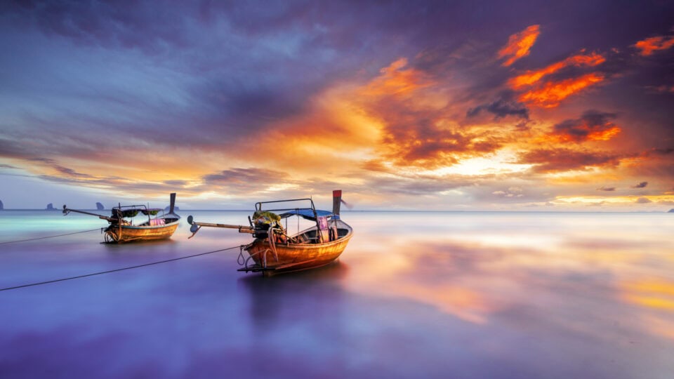 Serene boats under a colorful sunset.