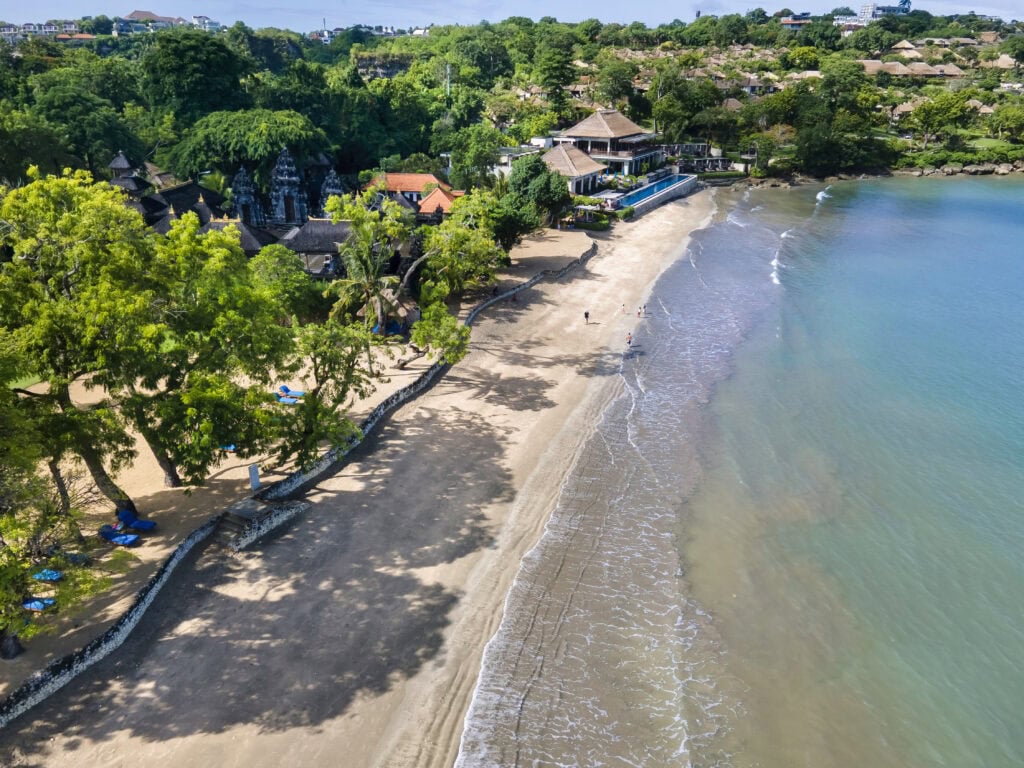 Serene beach with lush greenery.