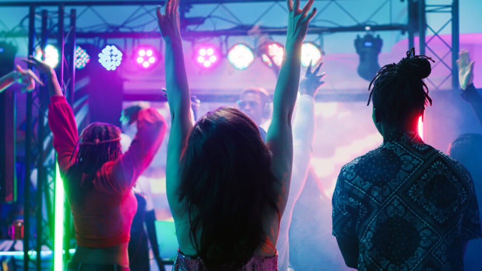 People dancing under colorful lights.