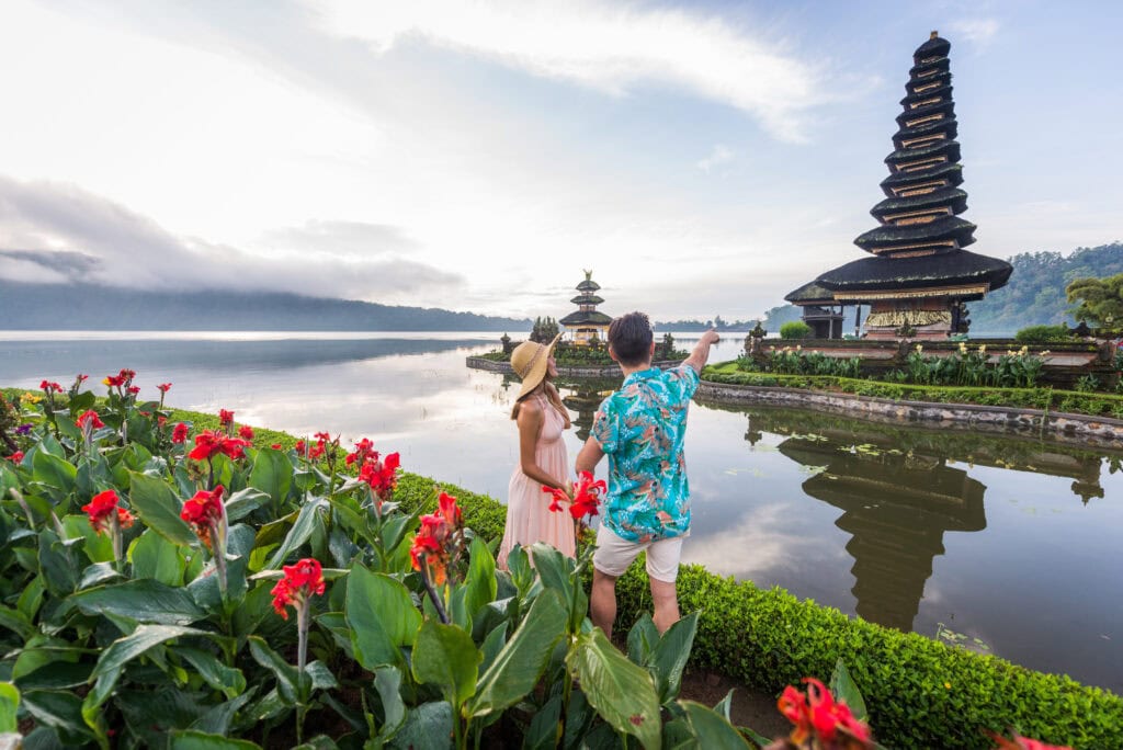 Couple admiring temple by lake.