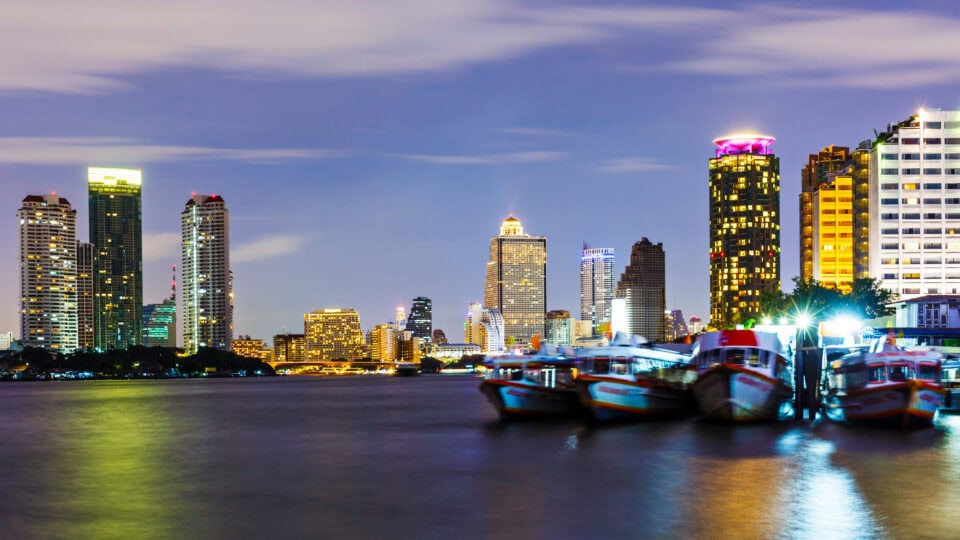 City skyline with illuminated buildings and boats