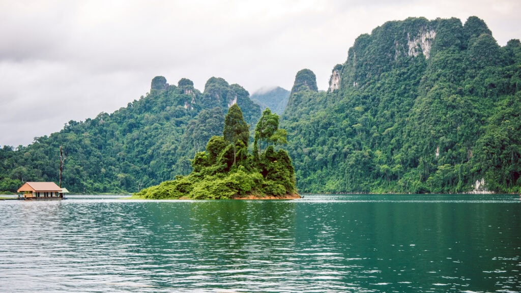 Serene lake surrounded by lush mountains.