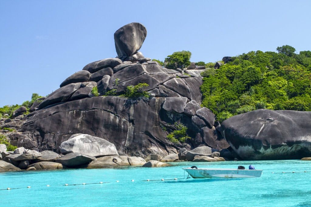 Unique rock formation by turquoise water.