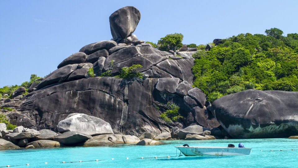 Unique rock formation by turquoise water.