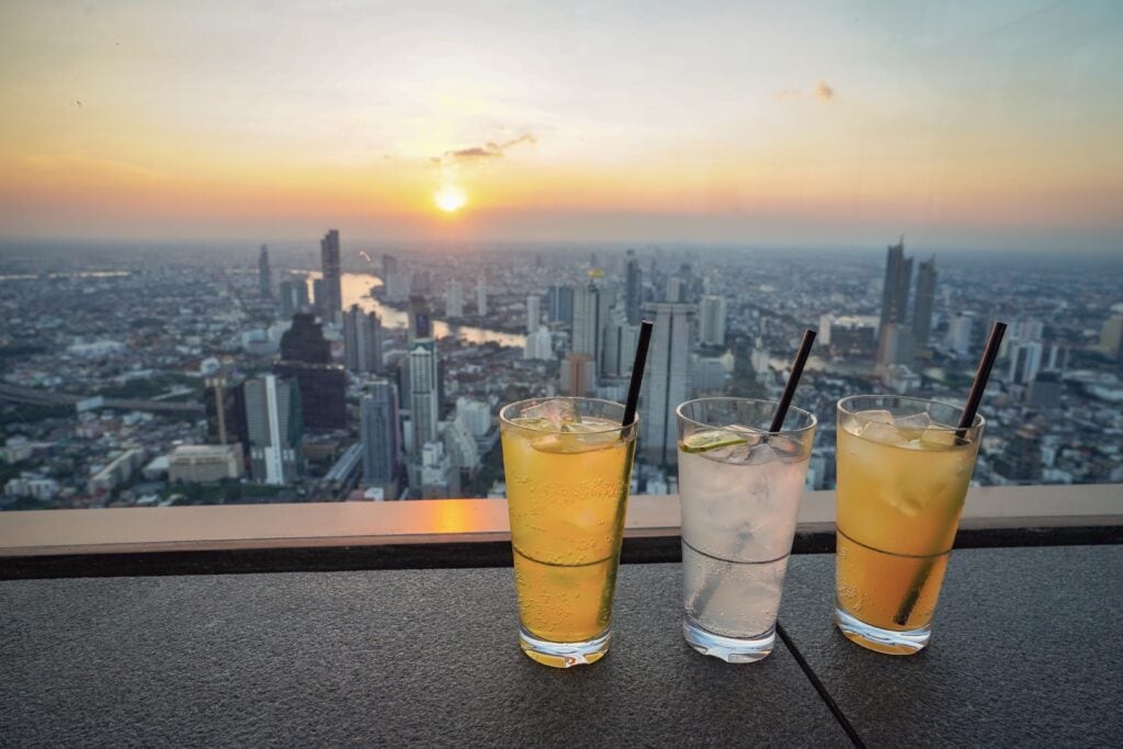 Drinks overlooking a sunset cityscape.