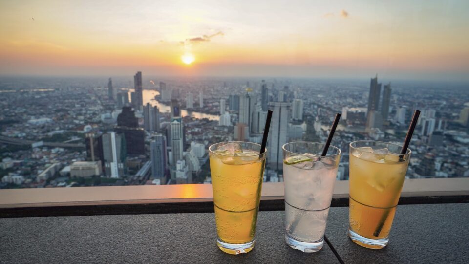 Drinks overlooking a sunset cityscape.