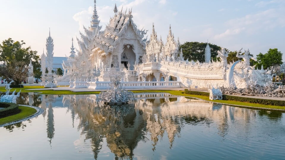 Stunning white temple reflecting in water.