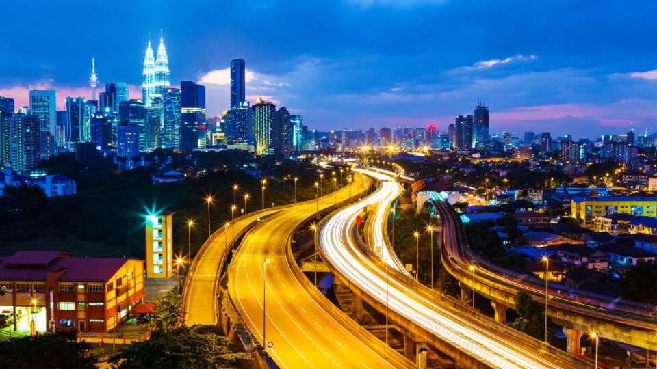 City skyline with illuminated highways at dusk