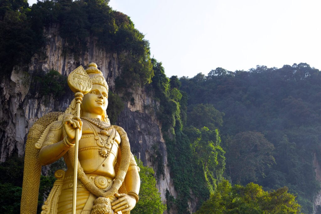 Golden statue against lush green backdrop
