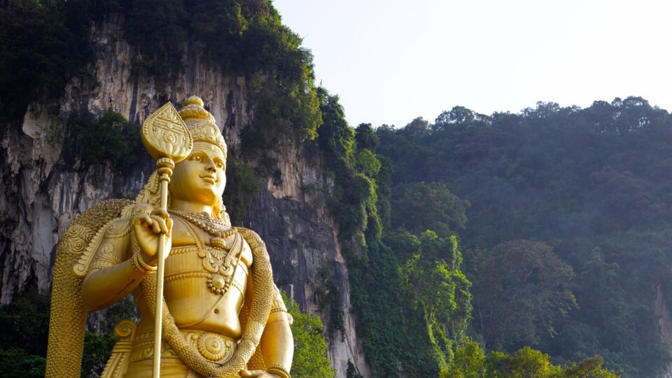 Golden statue against lush green backdrop