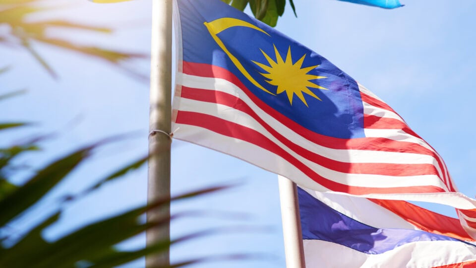 Flags fluttering against a blue sky.
