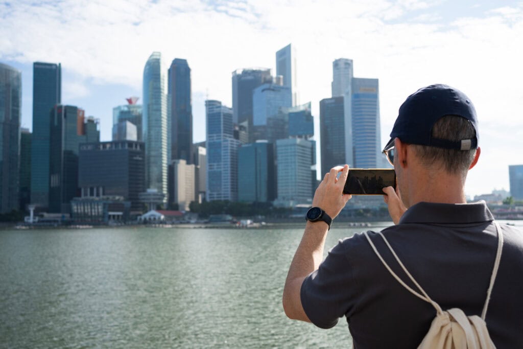 Tourist photographing Singapore skyline.